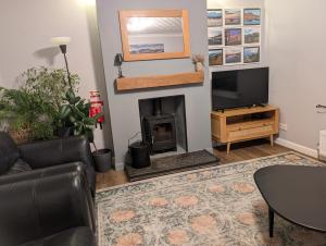 a living room with a fireplace and a tv at Self-catering in Portree in Portree