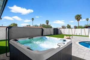a hot tub on a patio next to a pool at Rock and Glam Paradise in Mesa