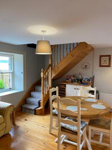 a dining room with a table and a staircase at The Cottage Bailieborough Cavan in Bailieborough +8 photos