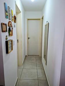 a hallway with a white door and a tile floor at Apartamento 2 Quartos com Piscina e Garagem in Maceió