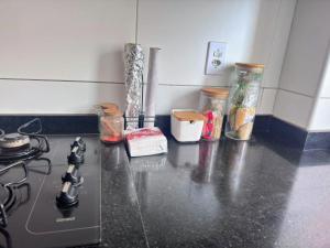 a kitchen counter with a stove and jars of food at Apartamento 2 Quartos com Piscina e Garagem in Maceió