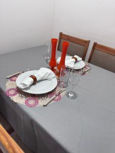 a table with plates and napkins and wine glasses at Apartamento 2 Quartos com Piscina e Garagem in Maceió