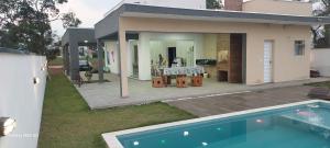 a house with a swimming pool in front of a house at Casa Condomínio Ninho Verde II in Pardinho