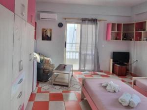 a living room with a pink bed and a checkered floor at Pinkapartment Saranda in Sarandë