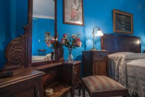ein Schlafzimmer mit einem Bett, einem Spiegel und einem Stuhl in der Unterkunft Casamuseo del Risorgimento in Lungro