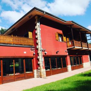 ein rotes Gebäude mit einem Balkon auf der Seite in der Unterkunft Txikierdi Alde in Oiartzun