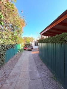 a sidewalk in front of a fence next to a house at Casa Las Condes, steps from Manquehue Metro in Santiago