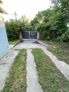 a driveway with a gate in a yard at Casa con quincho en el Volcán in El Volcán +1 photo