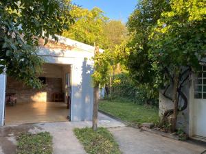 an entrance to a white building with a tree at Casa con quincho en el Volcán in El Volcán