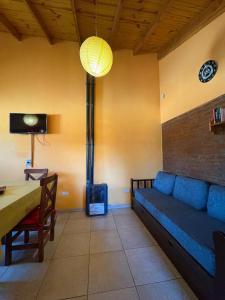 a living room with a blue couch and a table at Los Pinos in El Bolsón