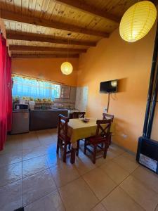 a dining room with a table and chairs and a kitchen at Los Pinos in El Bolsón