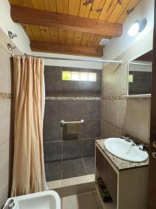 a bathroom with a sink and a shower at Los Pinos in El Bolsón +28 photos
