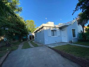 a small white house with a driveway at Casa con quincho en el Volcán in El Volcán
