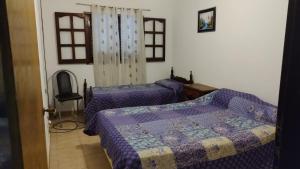 two beds in a room with purple comforters at Casa Aurora 1 Cosquín in Cosquín