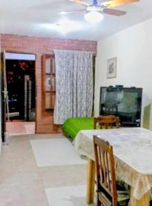 a dining room with a table and a green bed at Casa Aurora 1 Cosquín in Cosquín