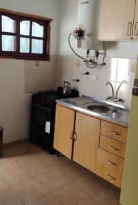 a kitchen with a stove and a sink at Casa Aurora 1 Cosquín in Cosquín