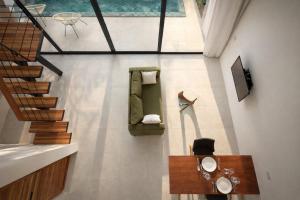 a living room with a green couch and a television at Sumba Luxury Pool Cottages in Ko Phangan