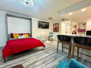 a bedroom with a red bed and a table and chairs at Mid-Century Modern Beachfront in Flagler Beach
