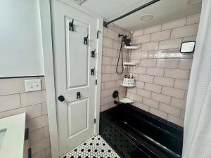 a bathroom with a white door and a black and white tiles at Mid-Century Modern Beachfront in Flagler Beach