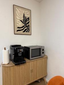 a microwave sitting on top of a wooden cabinet at Mete Stays - Modern - Workspace - Cool location in Ingolstadt