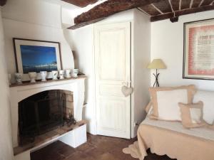 a living room with a fireplace and a bed at Ferienhaus in der Altstadt von Grimaud in Grimaud