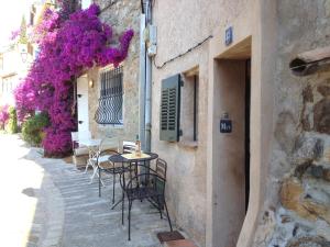 グリモーにあるFerienhaus in der Altstadt von Grimaudの紫の花が咲くパティオ(テーブル、椅子付)