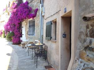 a patio with tables and chairs and purple flowers at Ferienhaus in der Altstadt von Grimaud in Grimaud