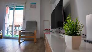 a living room with a television and a chair at Apartalux Benidorm's Port in Benidorm