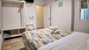 a bedroom with a bed with a pair of shoes on it at Apartalux Benidorm's Port in Benidorm