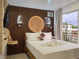 a bedroom with a bed with a large window at SilverLeaf in El Nido