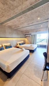 two beds in a room with a large window at GoldMen Vila do Mar Natal in Natal +257 photos