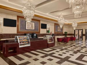 a hotel lobby with chandeliers and a check in counter at Swissotel Al Maqam Makkah in Mecca