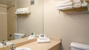 a bathroom with a sink and a mirror and towels at Cahilty #302 in Sun Peaks