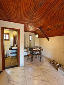 a living room with a table and a dining room at Pousada Villarejo in Monte Verde