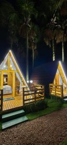a wooden house with a bed and a deck at chalé dos Buritis 01 in Chapada dos Guimarães