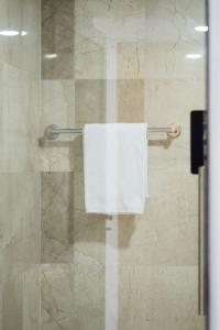a shower with a white towel on a glass door at Hotel alcazar de luna in Chilpancingo de los Bravos