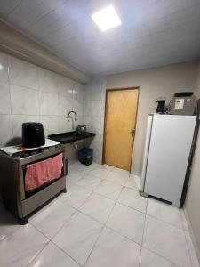 a kitchen with a stove and a refrigerator at Kit net da flor in Fortim