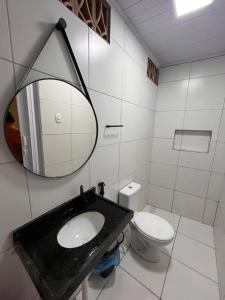 a bathroom with a sink and a toilet and a mirror at Kit net da flor in Fortim
