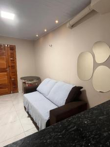 a bedroom with a bed and two mirrors on the wall at Kit net da flor in Fortim