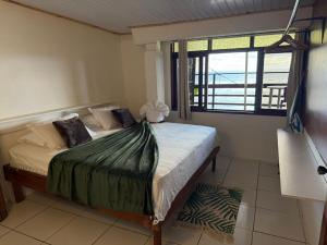 a bedroom with a bed with a view of the ocean at Ave Surfing House in Mahina