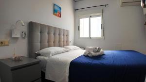 a bedroom with a bed with a stuffed animal on it at Apartalux Villa Playa in Benidorm