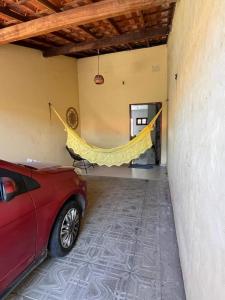 a red car parked in a room with a yellow hammock at Casa Flor e Ser Rua Onezinda da Costa Barros ,80 in Parnaíba