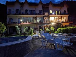 a building with a lot of chairs in front of it at Cabana Delfinul - Cazanele Dunarii in (( Plavişeviţa ))