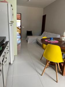 a kitchen with a table and a yellow chair at Casa Flor e Ser Rua Onezinda da Costa Barros ,80 in Parnaíba +7 photos