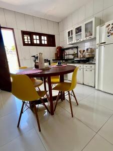 a kitchen with a wooden table and yellow chairs at Casa Flor e Ser Rua Onezinda da Costa Barros ,80 in Parnaíba