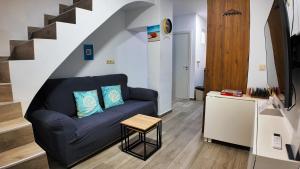 a living room with a blue couch and stairs at Apartalux Villa Playa in Benidorm