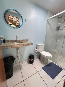 a bathroom with a toilet and a sink and a mirror at Casa Lima in Imperatriz