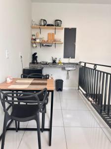 a dining room with a table and chairs and a kitchen at Casa Lima in Imperatriz +3 photos