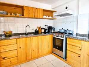 a kitchen with wooden cabinets and a stove top oven at Hotel and Country House Valle Sagrado de los Incas in Huaran