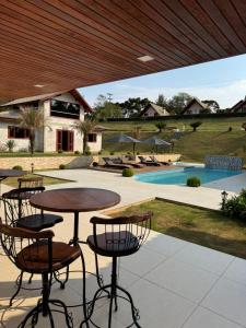 a patio with a table and chairs and a pool at Pousada Villarejo in Monte Verde